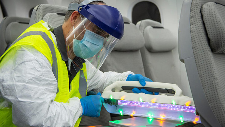 A crew member sanitizing a high-touch surface.